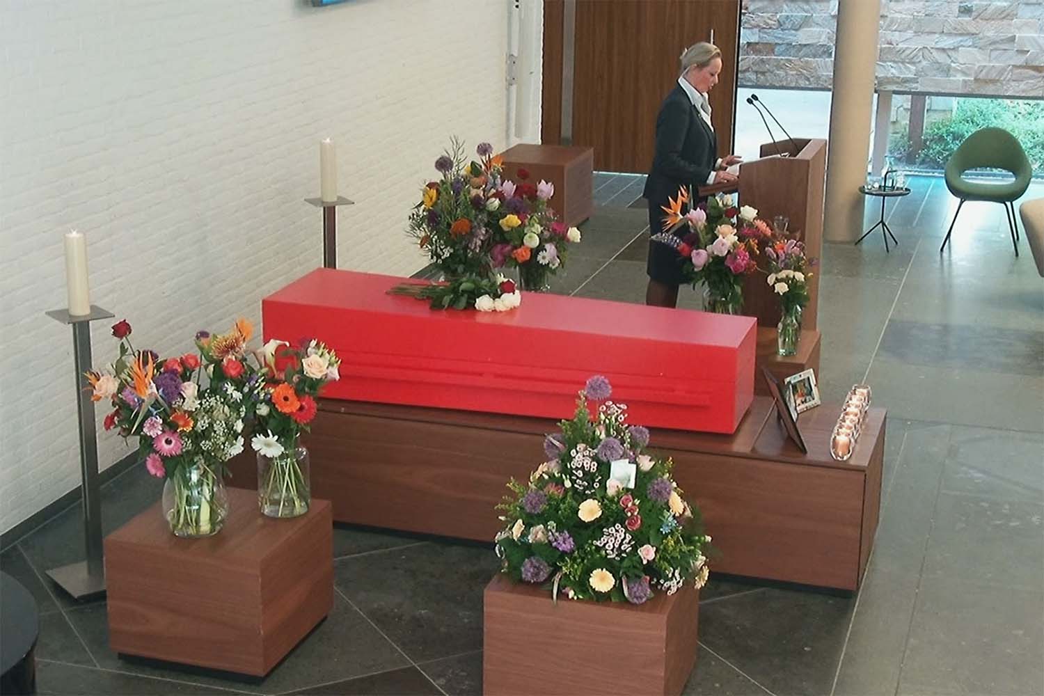 Persoonlijke uitvaartkist in verkeersrood: een laatste eerbetoon aan haar creatieve leven